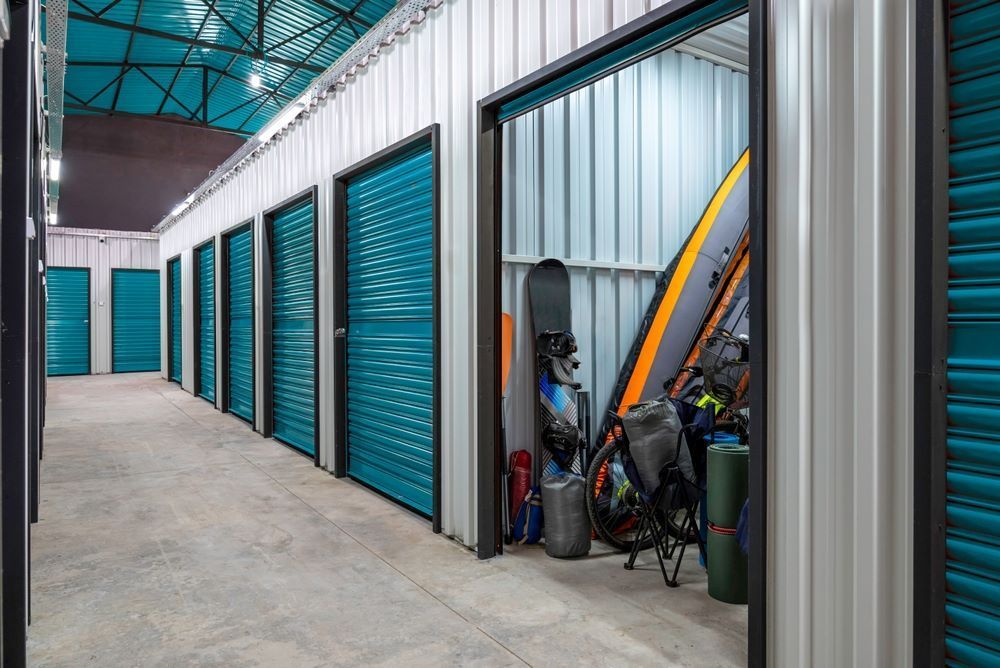 A Row of Storage Units With Blue Doors Filled With Various Items — AKM Self Storage In Huntlee, NSW