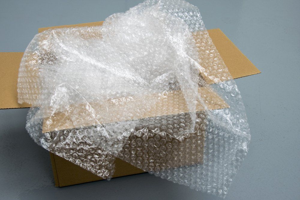 A Cardboard Box Covered in Bubble Wrap on a Table — AKM Self Storage In Kurri Kurri, NSW