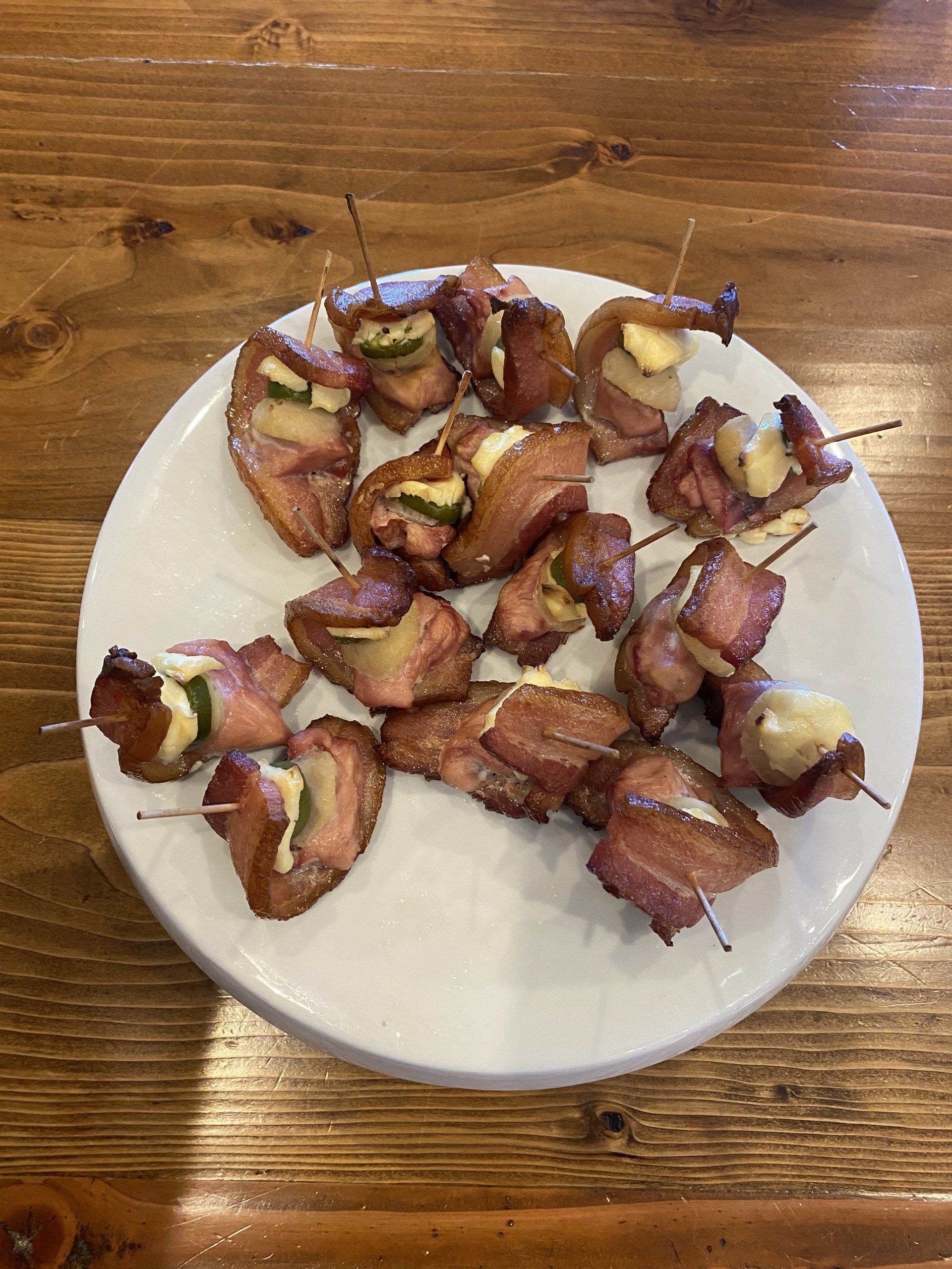 Plate of bacon-wrapped appetizers on a wooden table