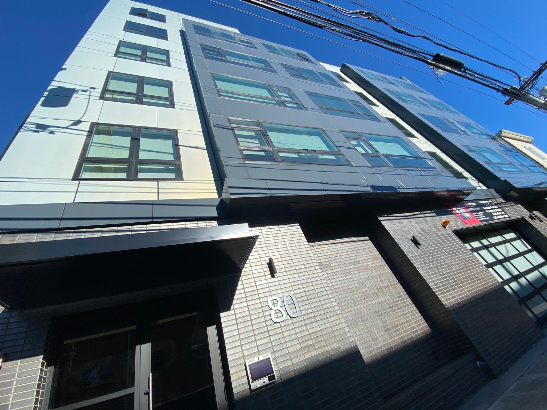 A large building with a lot of windows and a blue sky in the background.