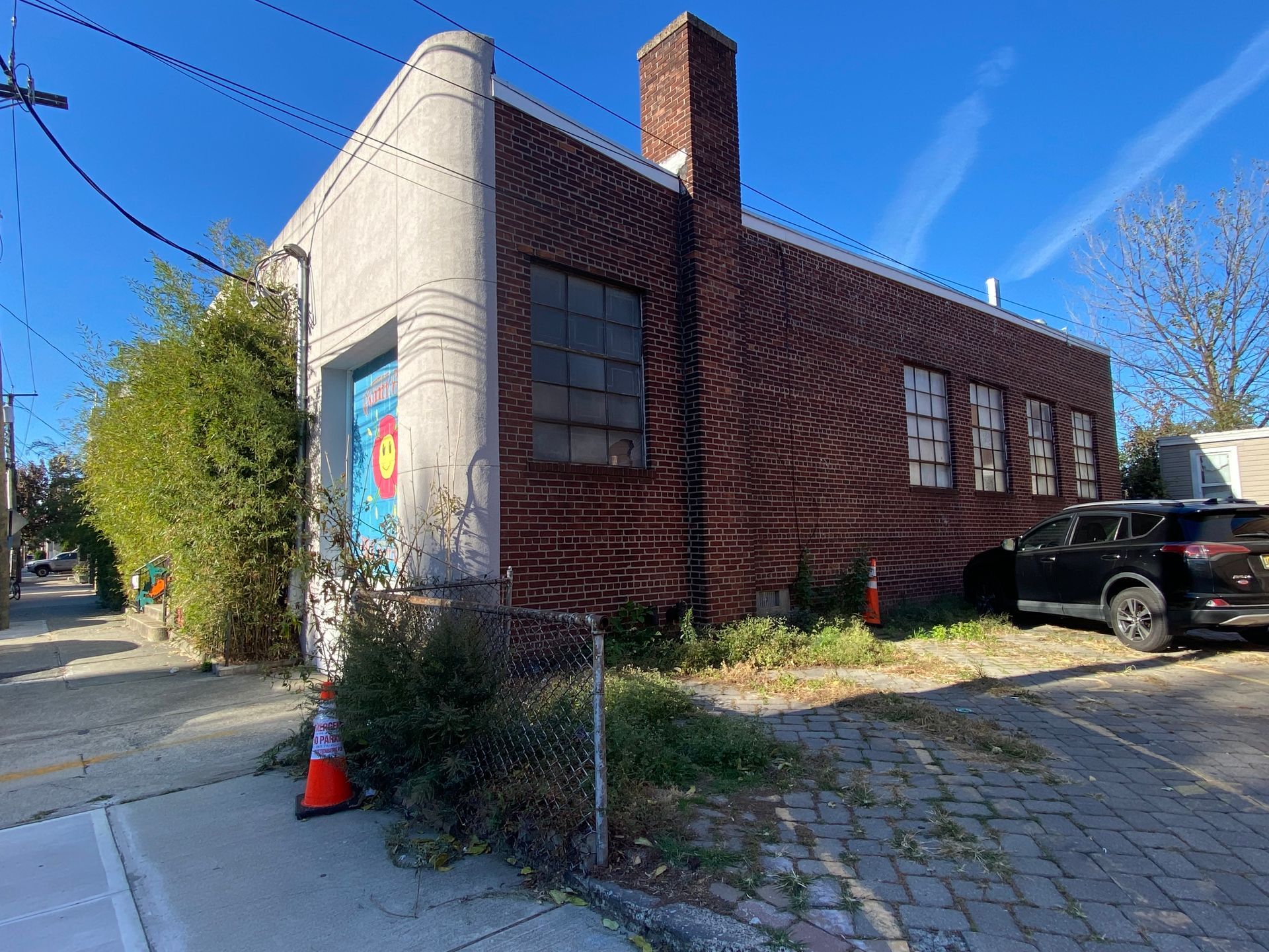A brick building with a car parked in front of it.