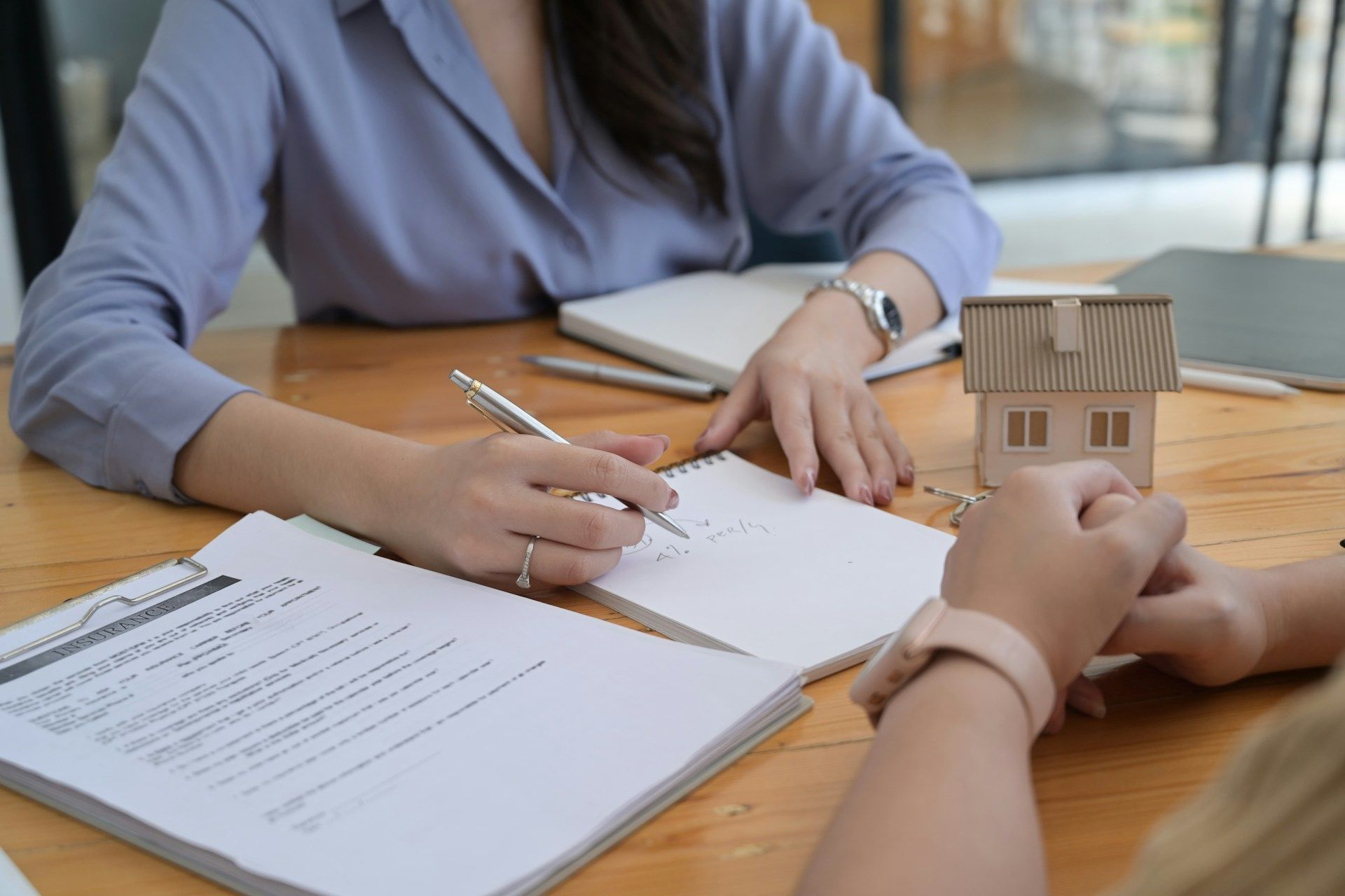 Family in kitchen: Father helps daughter with homework at table; siblings in background.