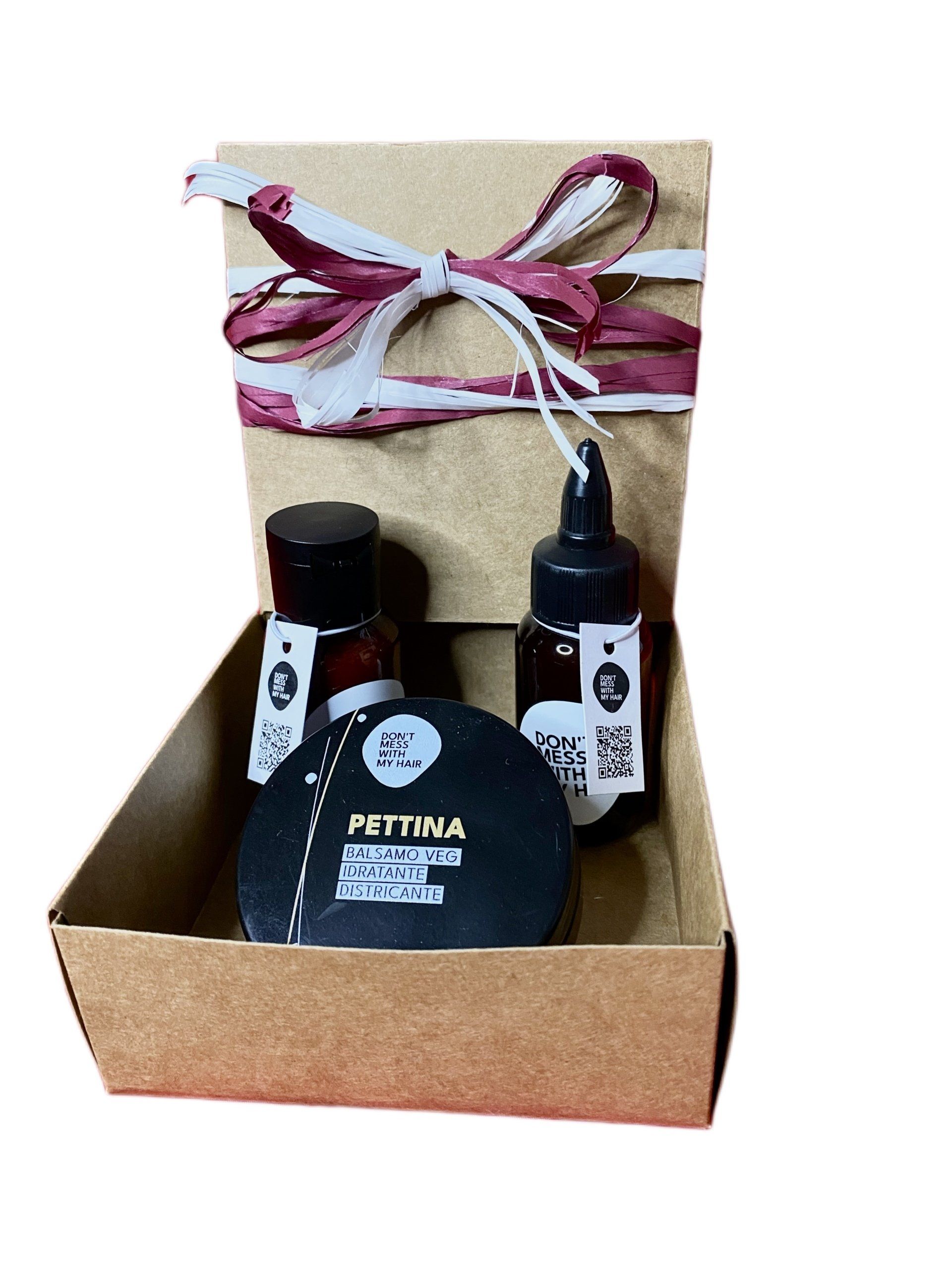 Scatola regalo con due bottiglie e un barattolo, legati con un nastro.