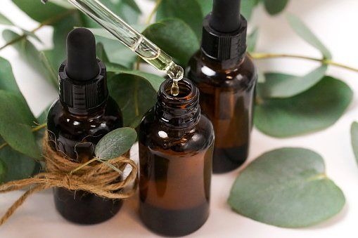 Flaconi marroni di oli essenziali con contagocce, foglie di eucalipto.