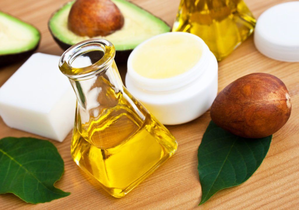 Avocado, olio, crema e sapone sulla superficie del legno.