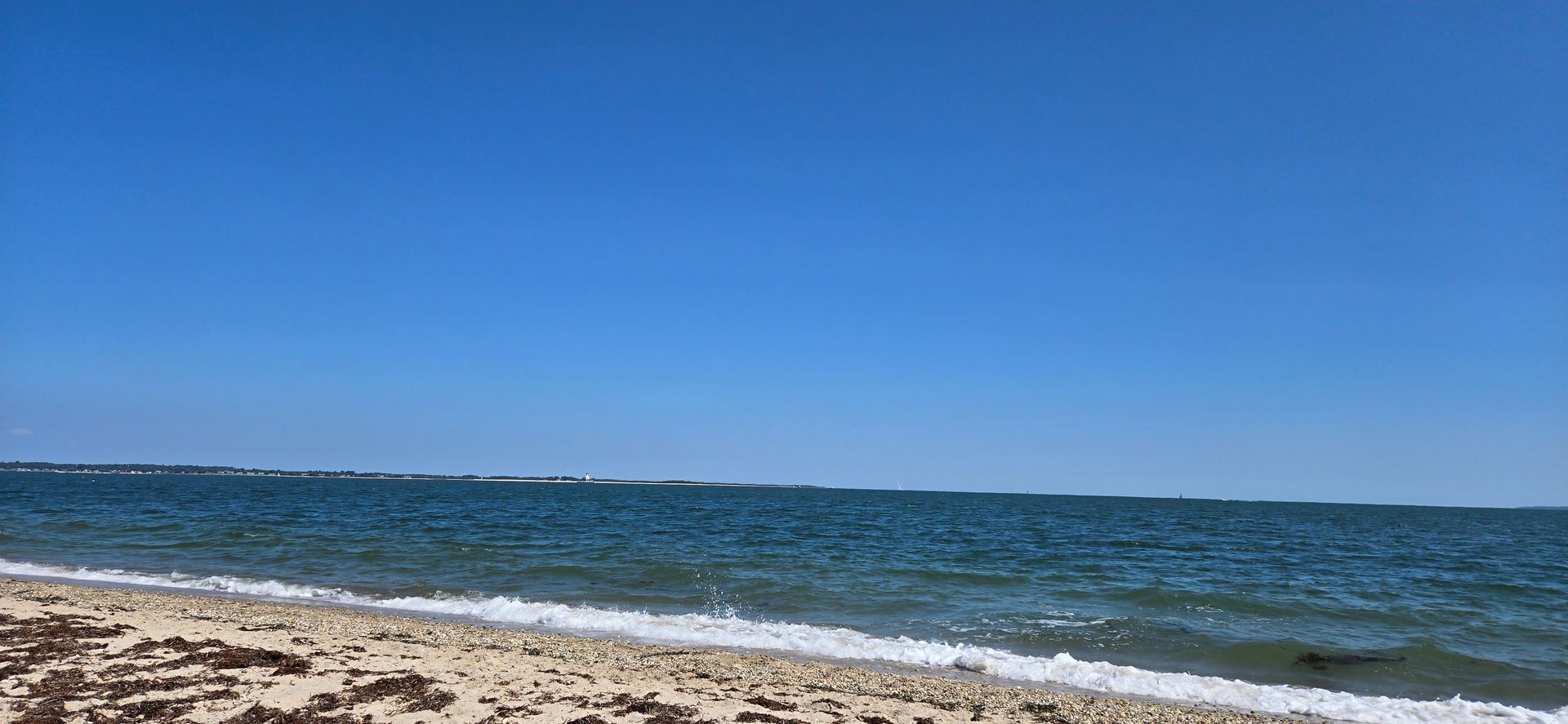 Menhaden lane beach with long beach bar lighthouse in distance