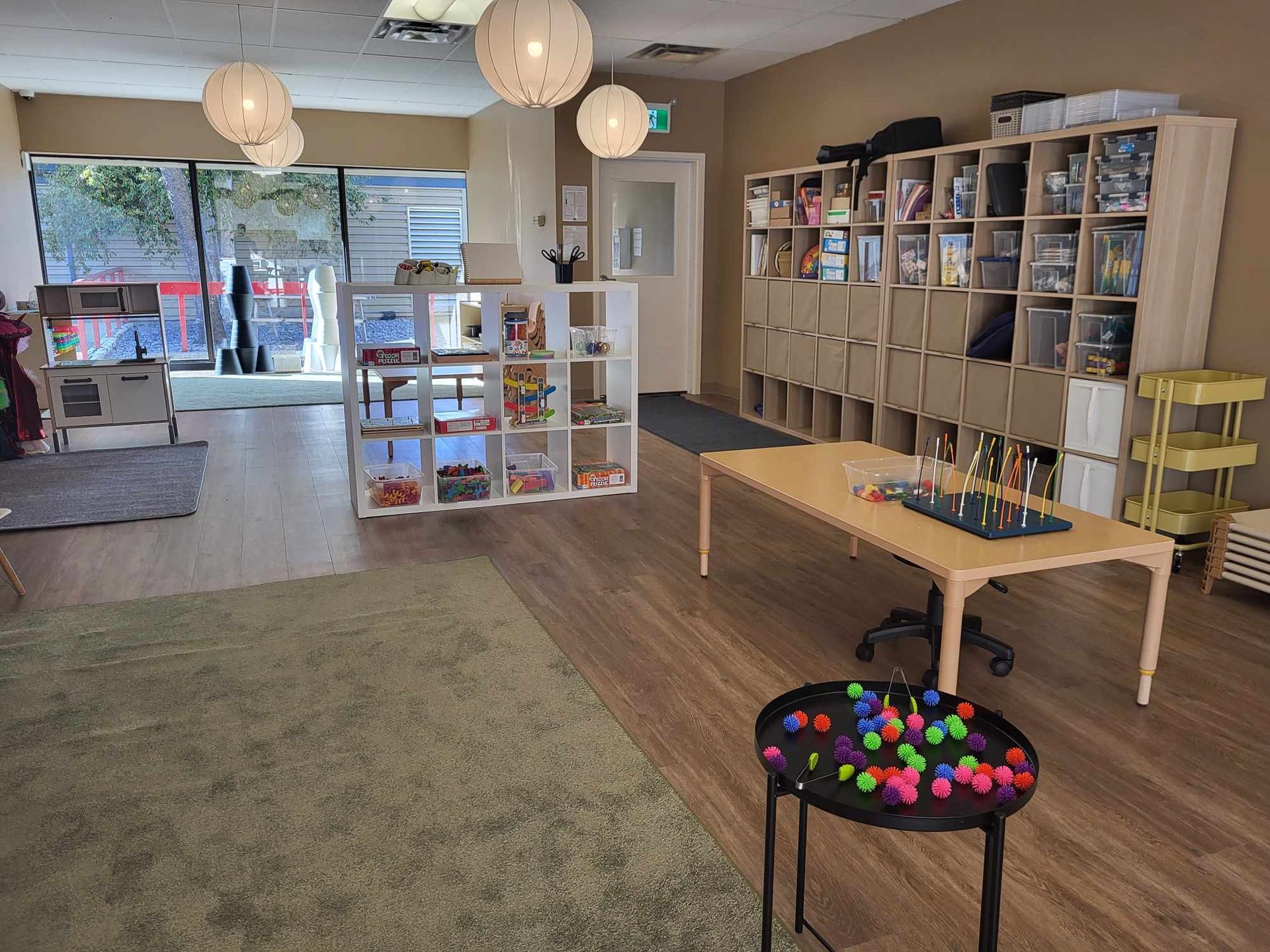 There is a table with balls on it in the middle of the room.