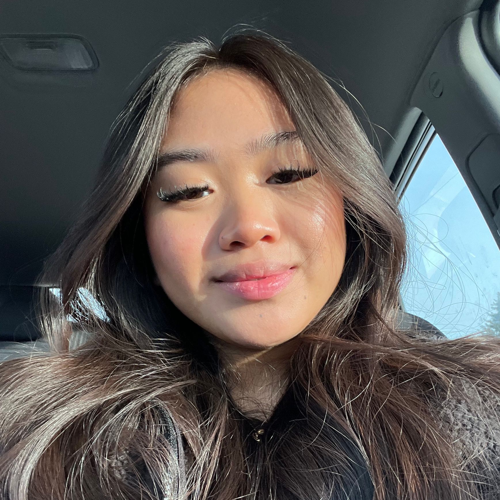 A close up of a woman 's face in a car.