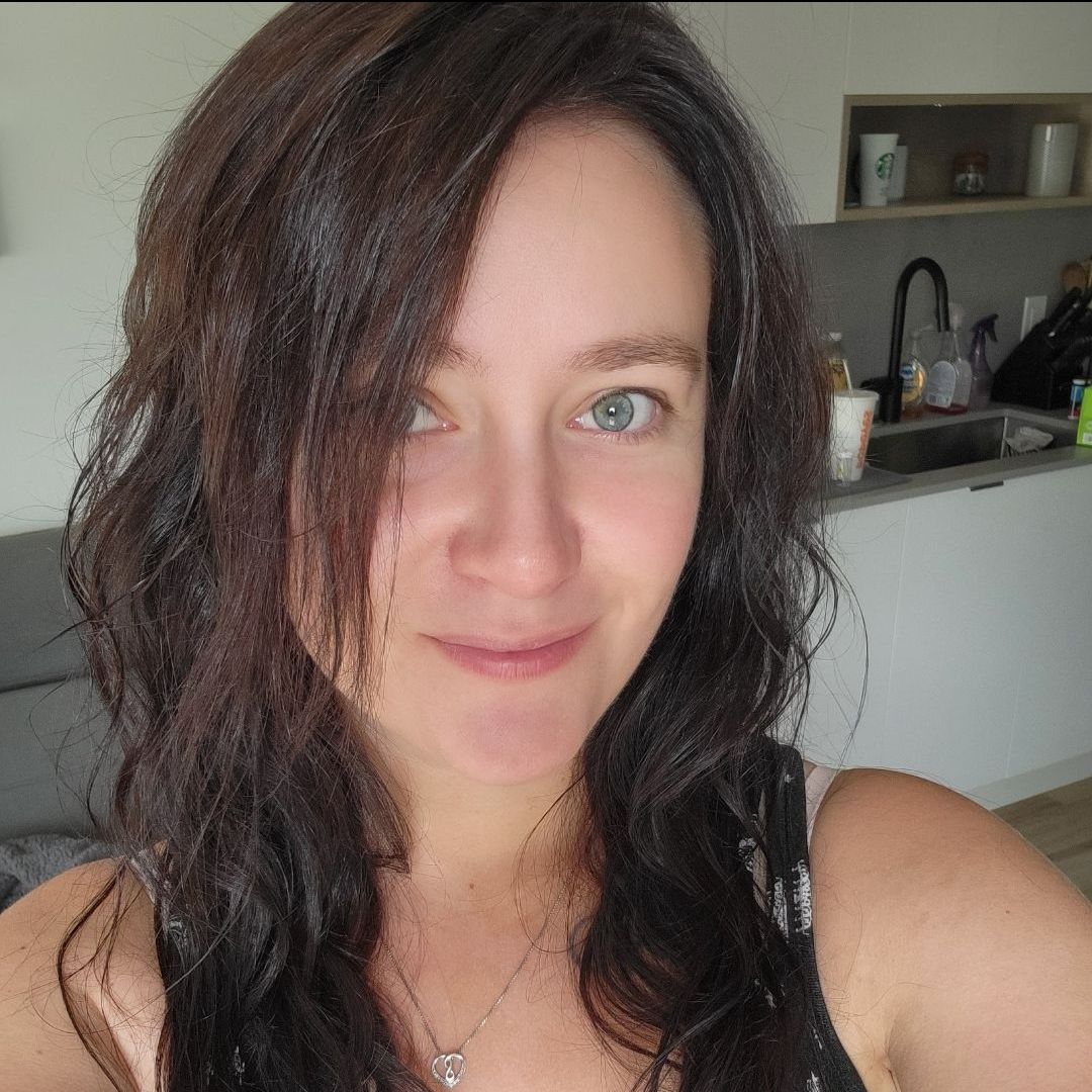 A woman with long hair is taking a selfie in a kitchen.