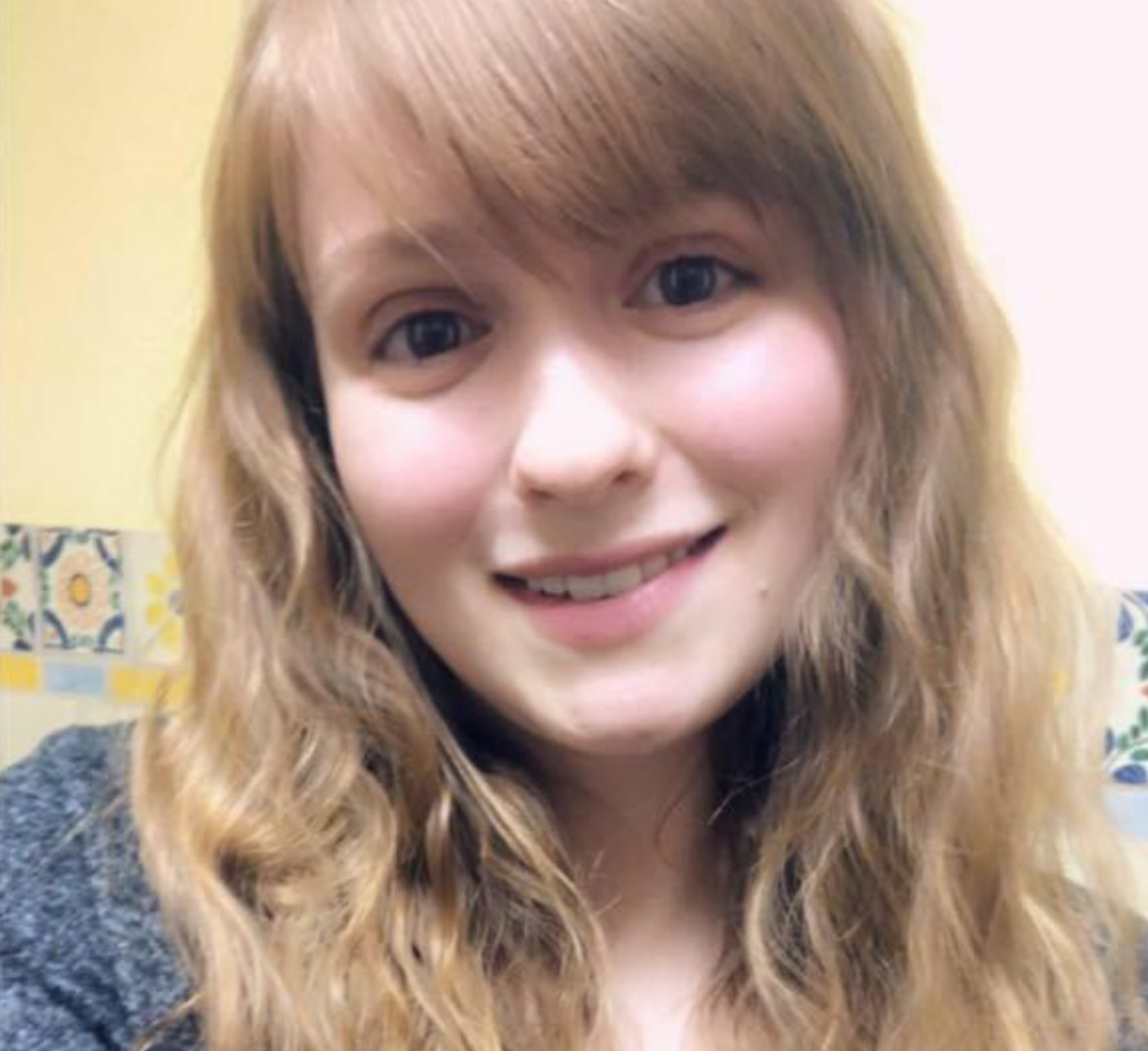 A woman with long blonde hair is smiling for the camera.