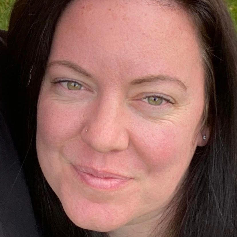 A close up of a woman 's face with a smile on her face.