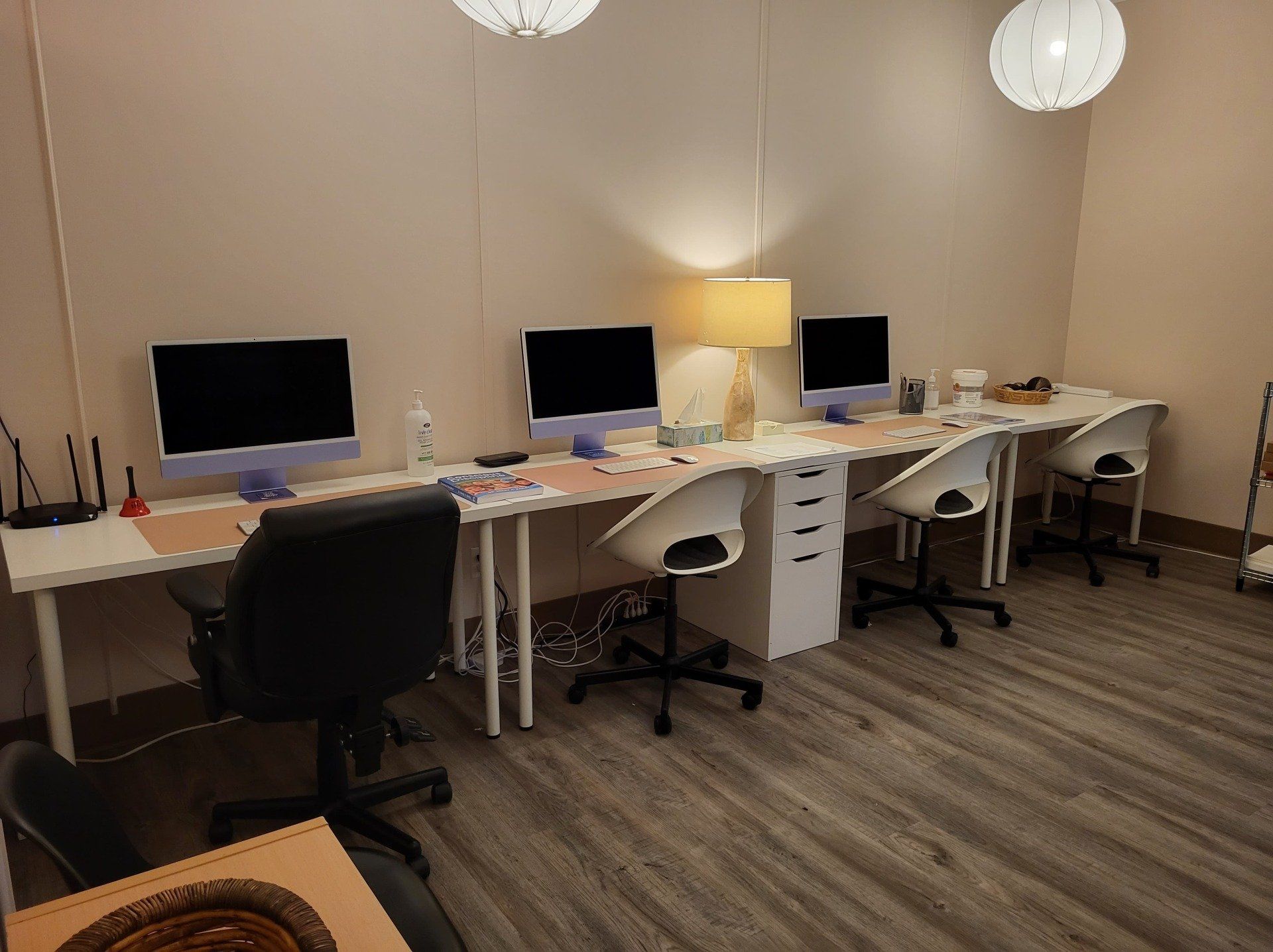 A room with a lot of desks and chairs with computers on them.