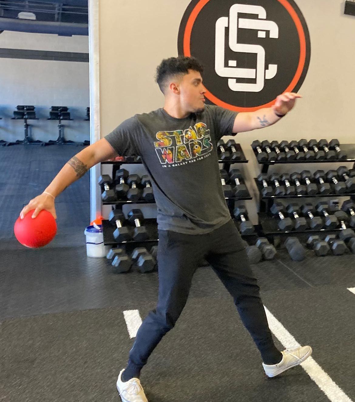 A Man In A Star Wars Shirt Is Throwing A Ball - Chicago, IL - Fast Track Physio