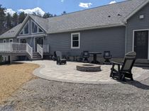 A house with a patio featuring a fire pit, Adirondack chairs, and other seating.