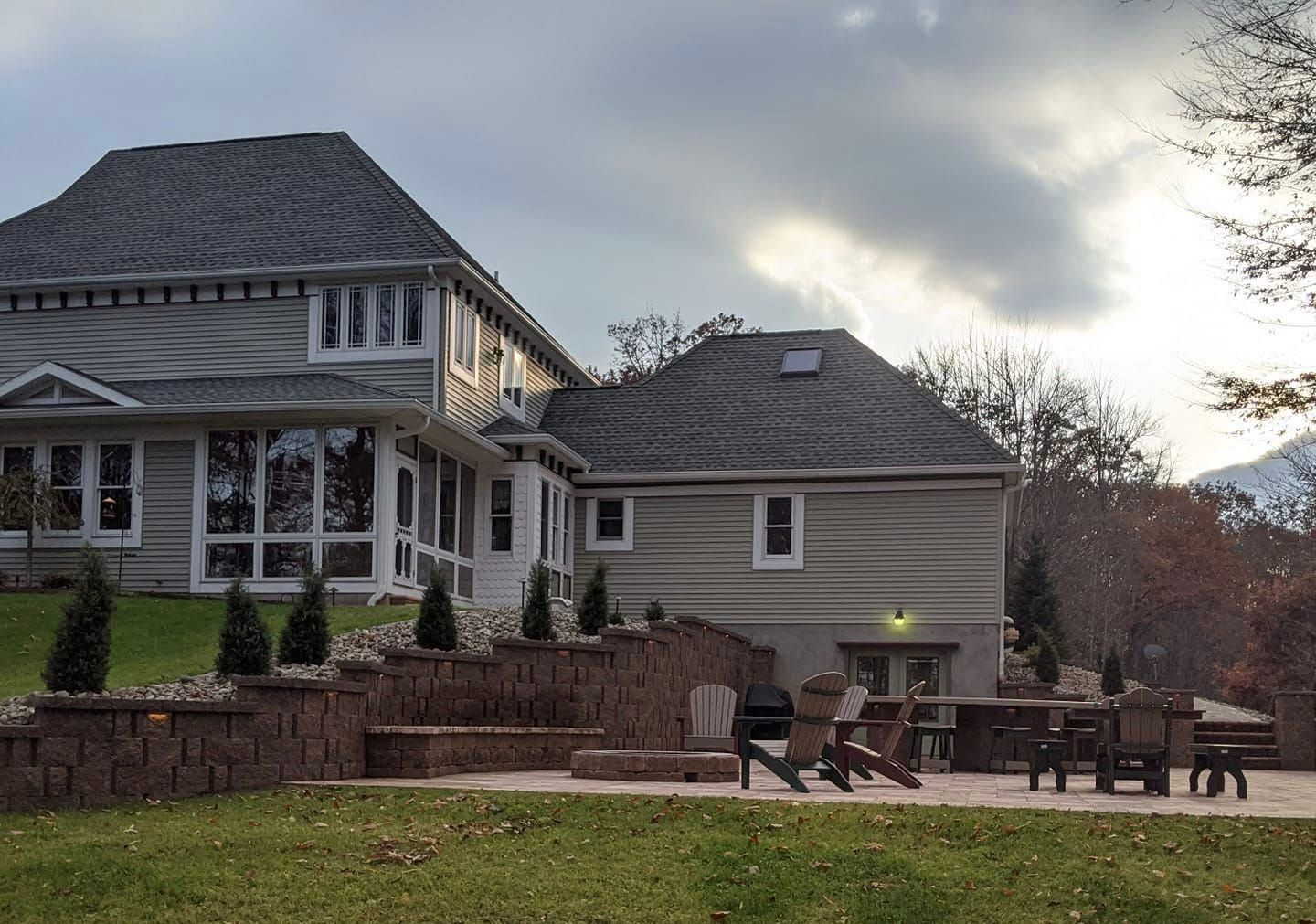 Exterior view of a house with brick and white siding. New stone walkway and steps lead to the front door.