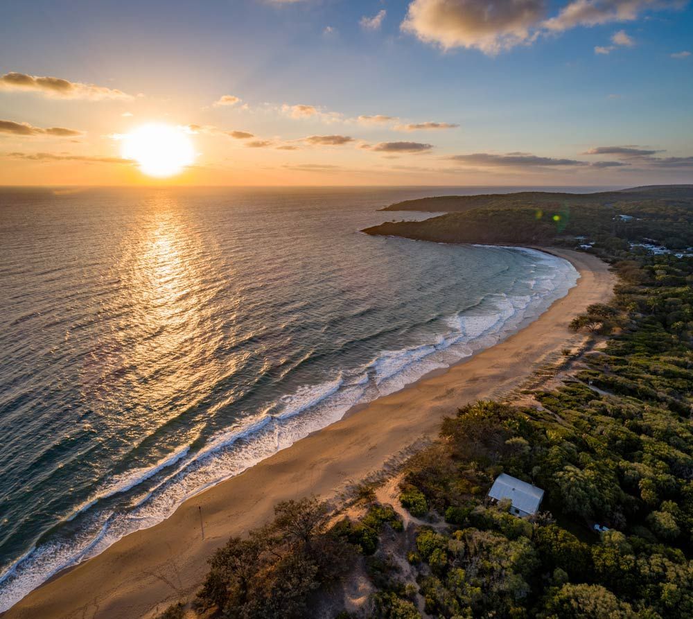An Aerial View of a Beach and Ocean at Sunset  — Anthony Cameron Electrical & Solar in Agnes Water, QLD