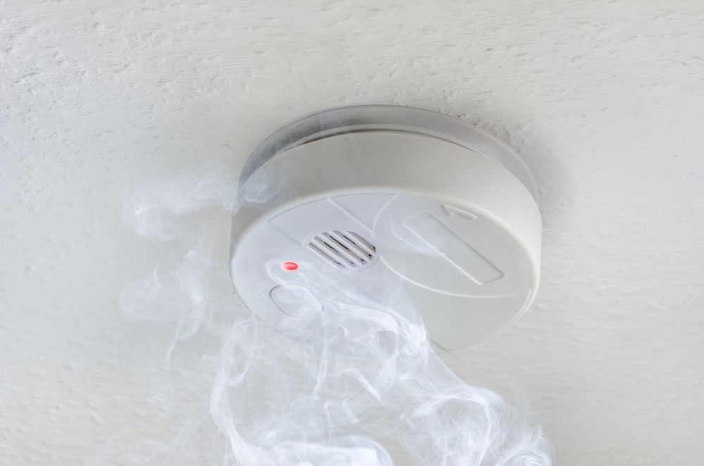 Smoke Detector With Smoke Coming Out Of It — Anthony Cameron Electrical & Solar in Kepnock, QLD