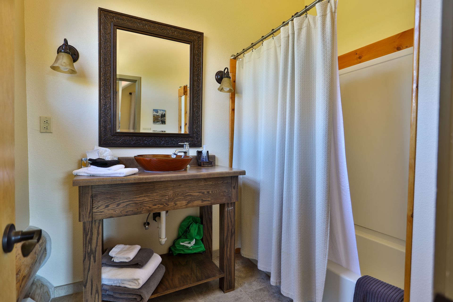 A bathroom with a sink , mirror and shower curtain.