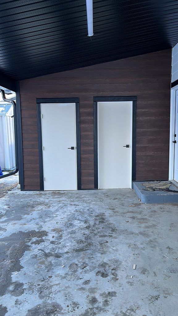 Two white doors are sitting next to each other in a building.