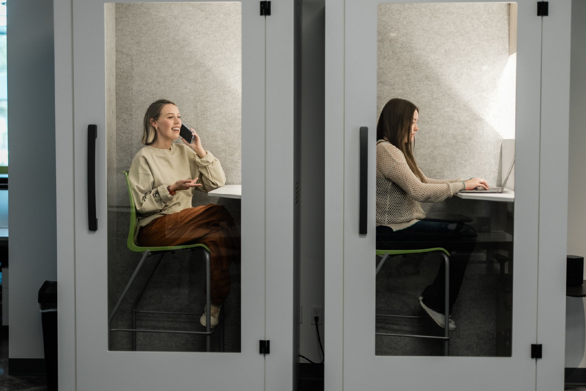 a woman in a call booth at a coworking space