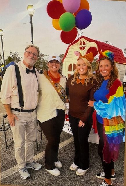 A group of people posing for a picture with balloons in the background