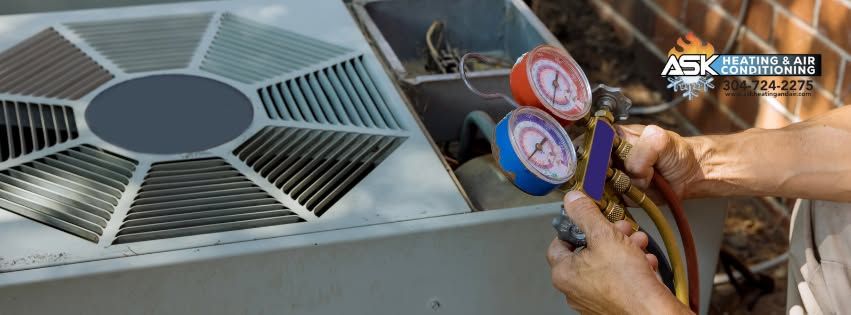 Technician checking an HVAC unit’s fan grille with pressure gauges attached