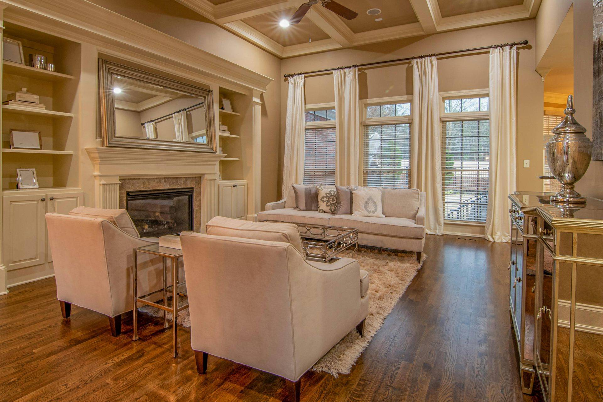 Modern kitchen and dining area with wood, white, and gold accents, featuring table and chairs.