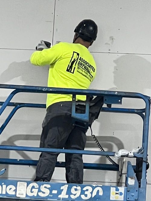 A man is working on a wall on a lift that says gs 1930