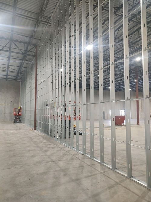 A large warehouse with a lot of metal frames on the walls.