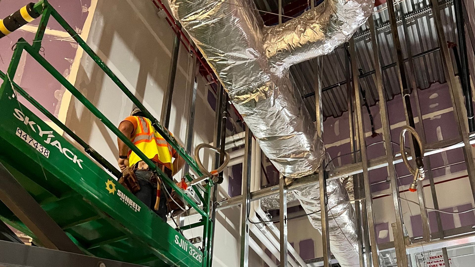 A man is standing on a lift in a building.