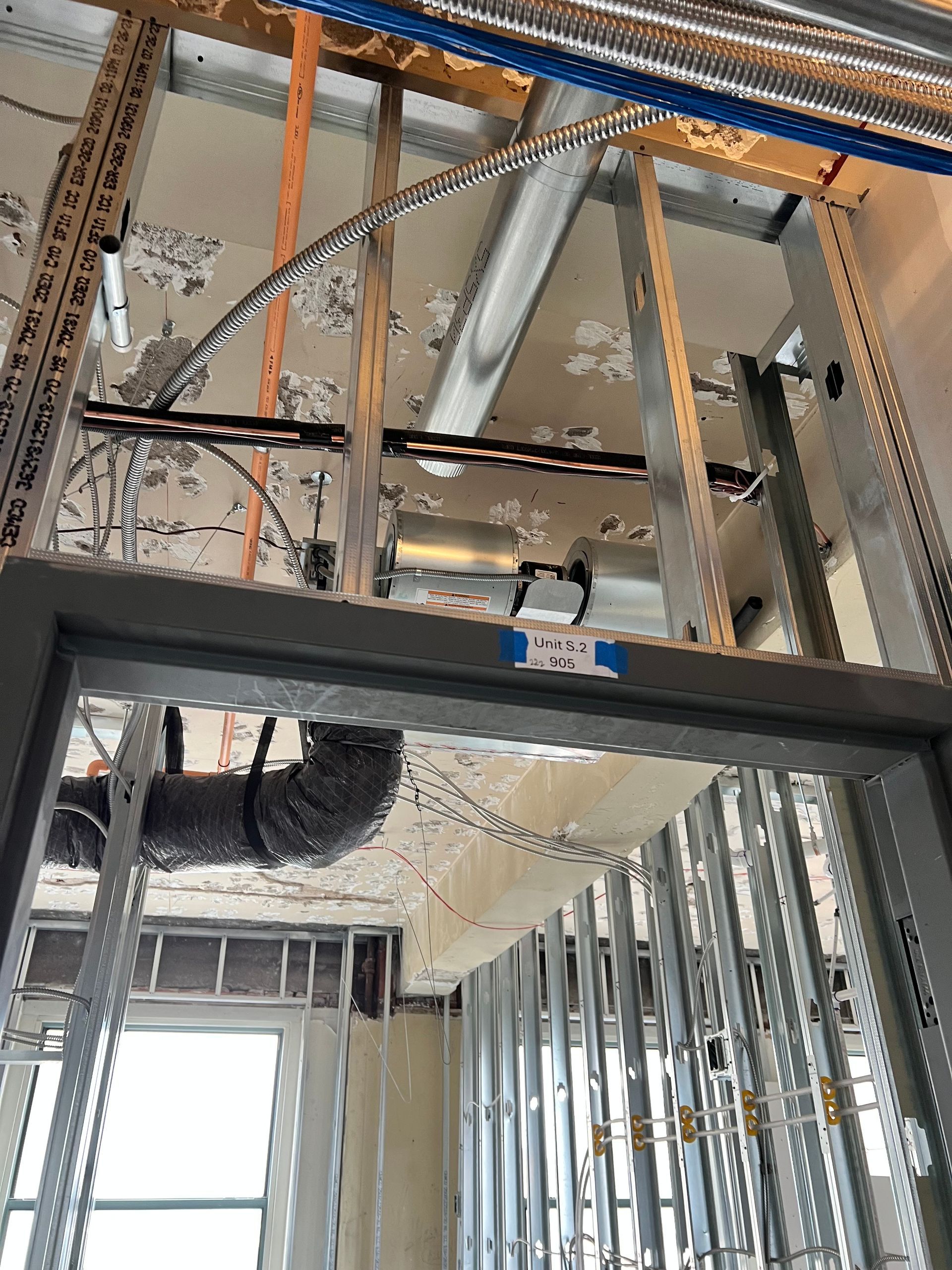 A ladder is hanging from the ceiling of a building under construction.