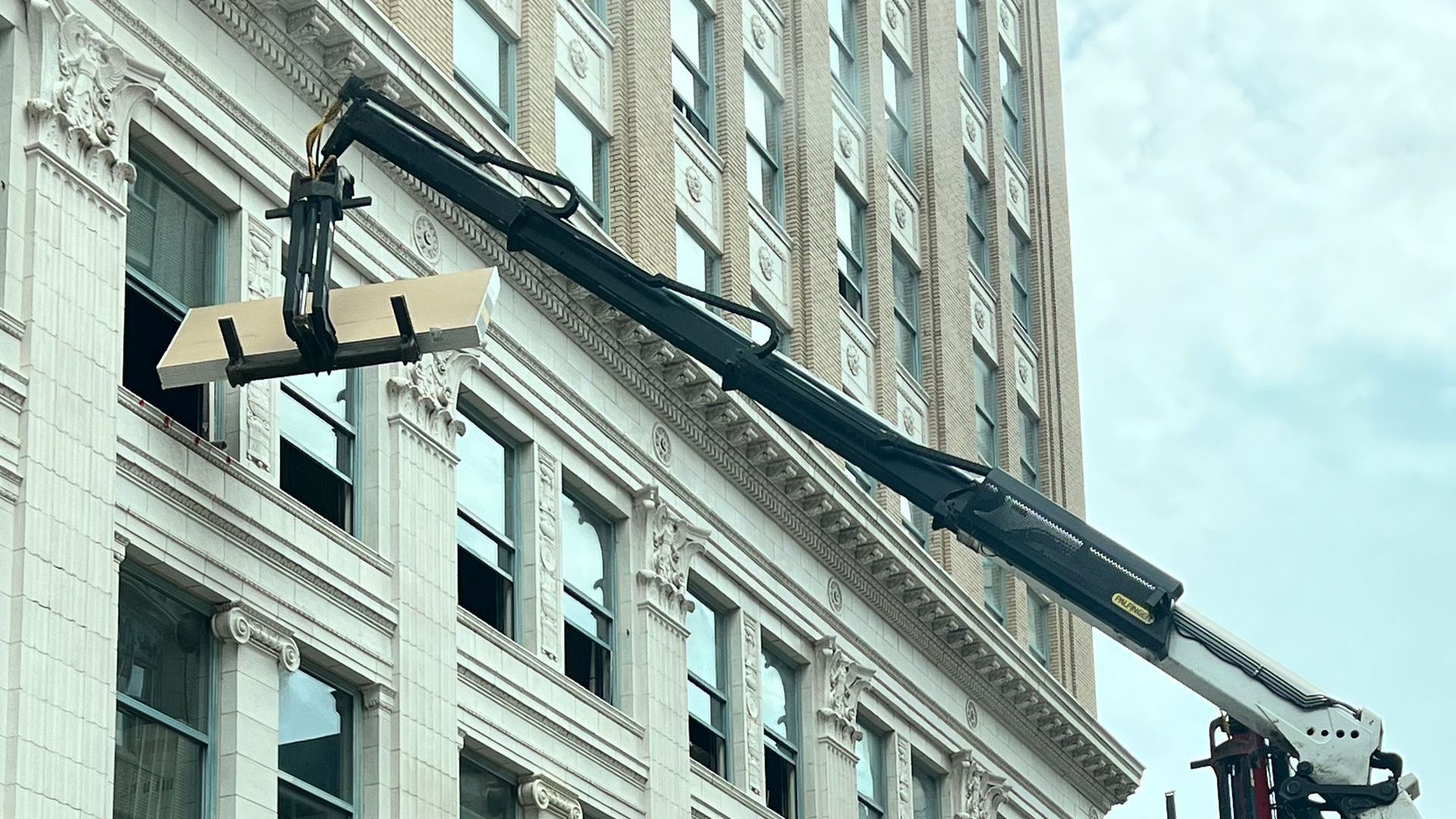 A large building with a crane attached to the side of it.
