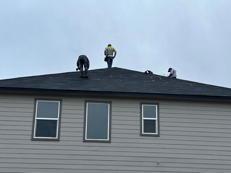 Roofing crew installing new shingles