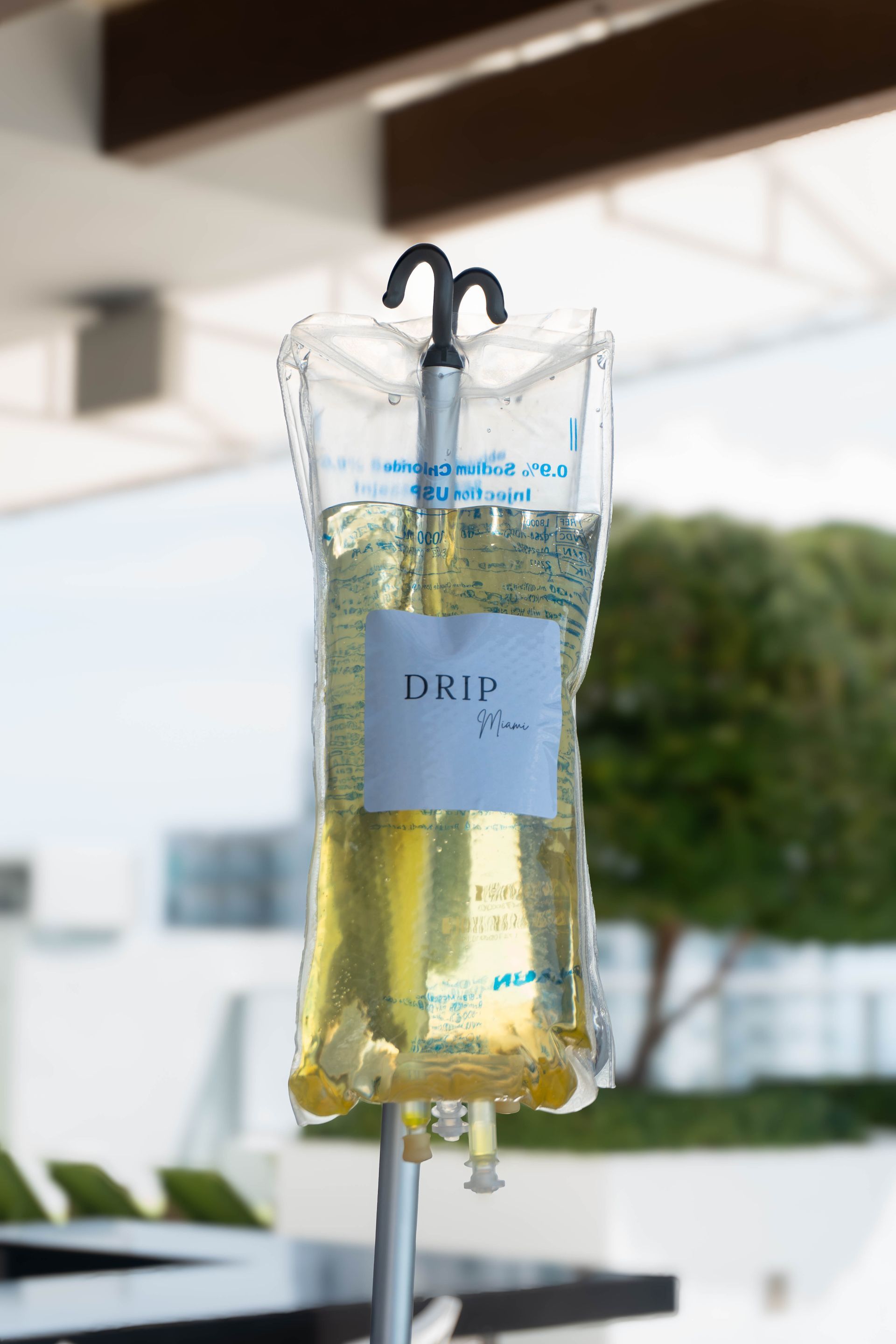 IV bag on a stand filled with yellow liquid, labeled