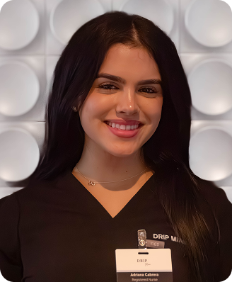 Woman in black scrubs smiles at the camera, a name tag reads