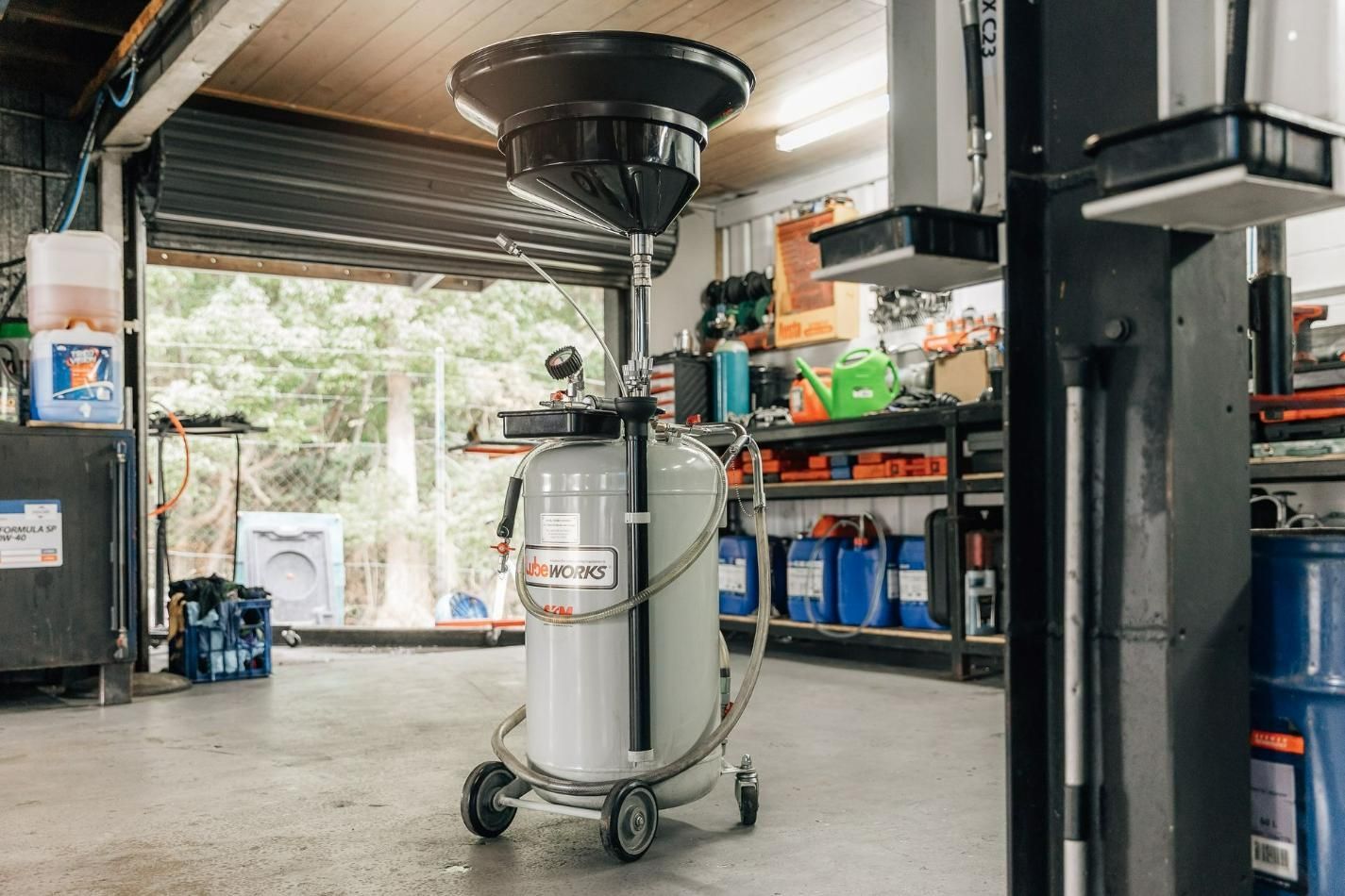 A Vacuum Cleaner Is Sitting In A Garage Next To A Lift — RNA Mechanical In Yandina, QLD