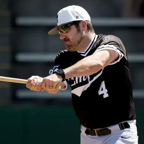 Man in White Sox uniform swings a baseball bat.
