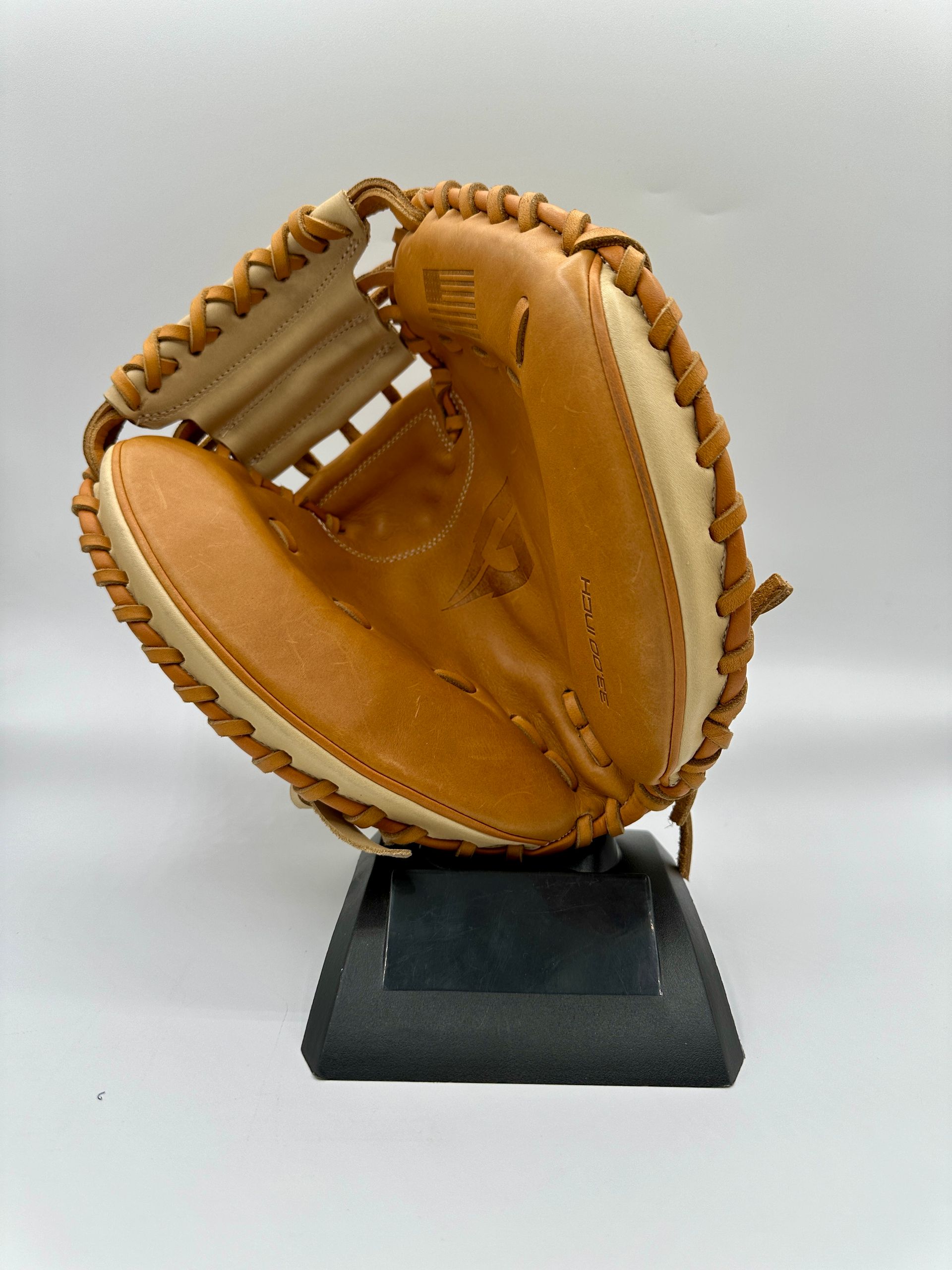 A brown baseball glove is sitting on a black base