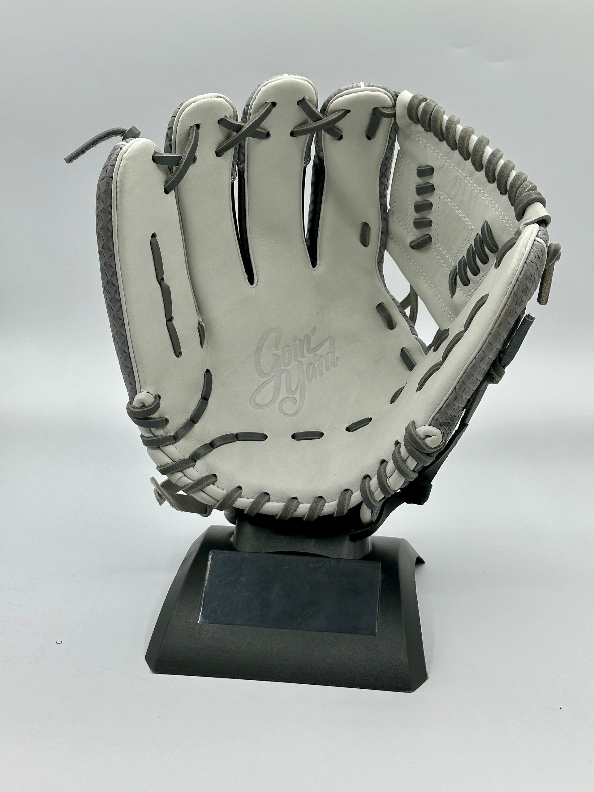 A white baseball glove is sitting on top of a black base.
