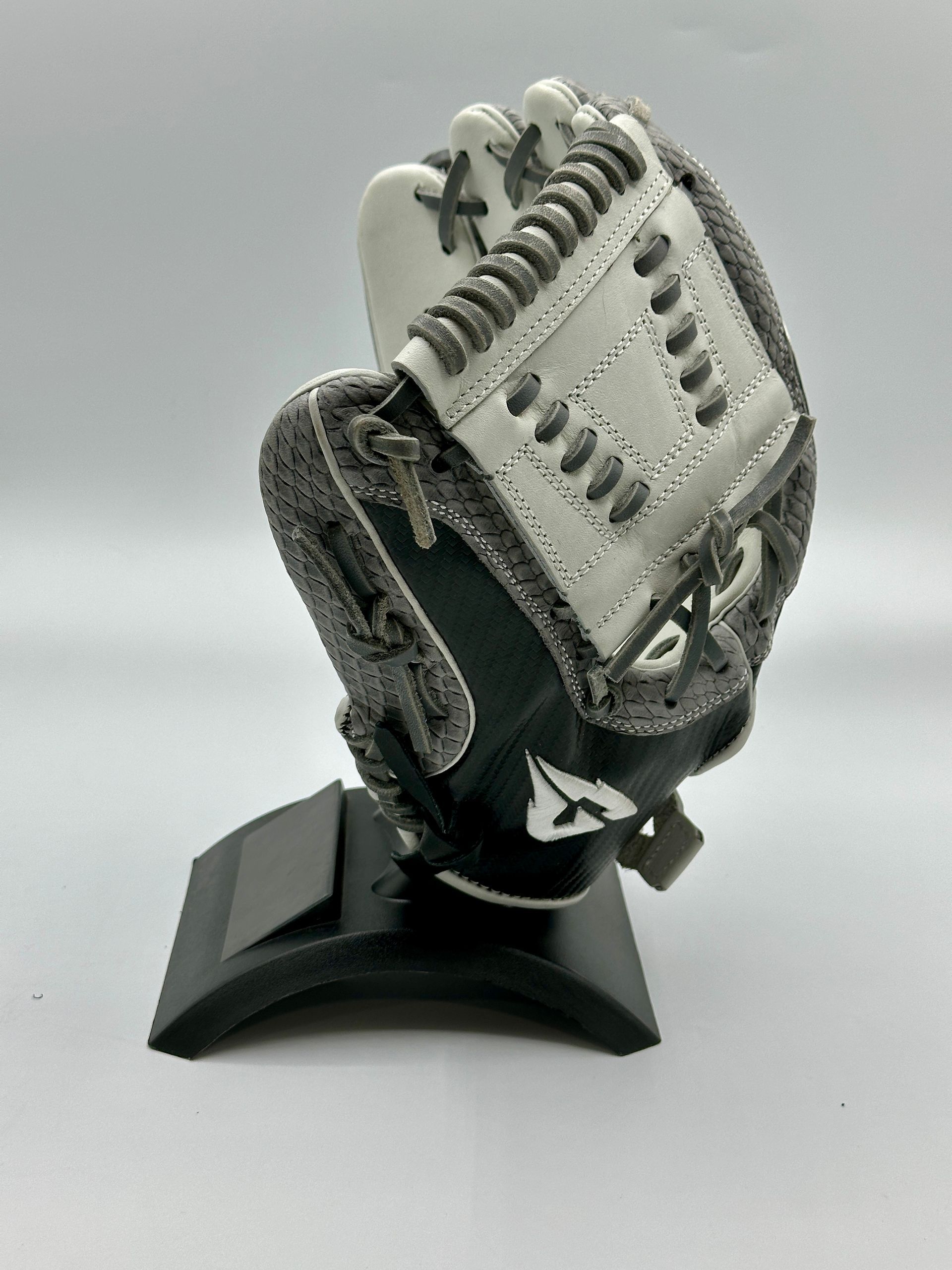 A baseball glove is sitting on top of a black stand.