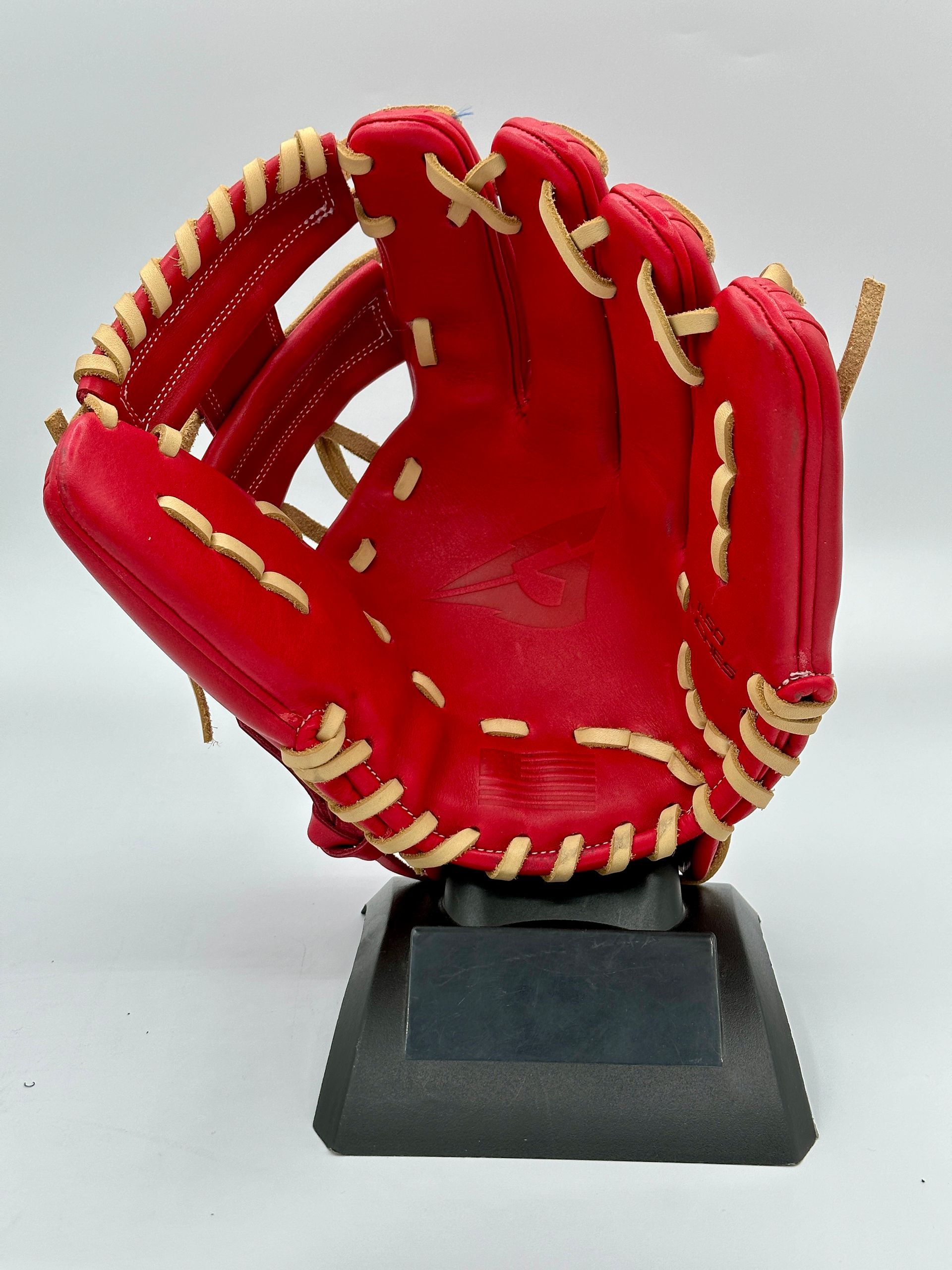 A red baseball glove is sitting on a black base