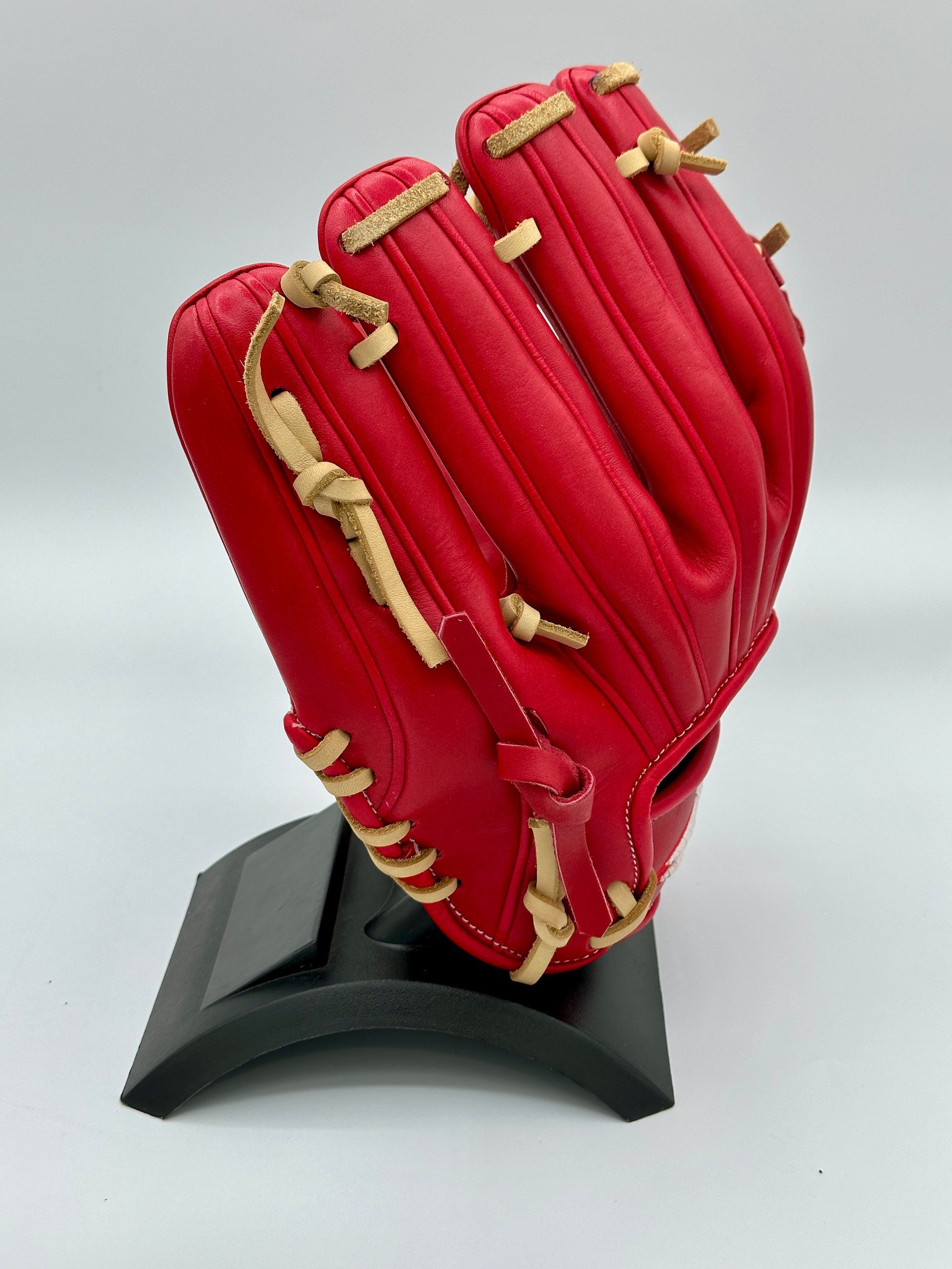 A red baseball glove is sitting on a black stand