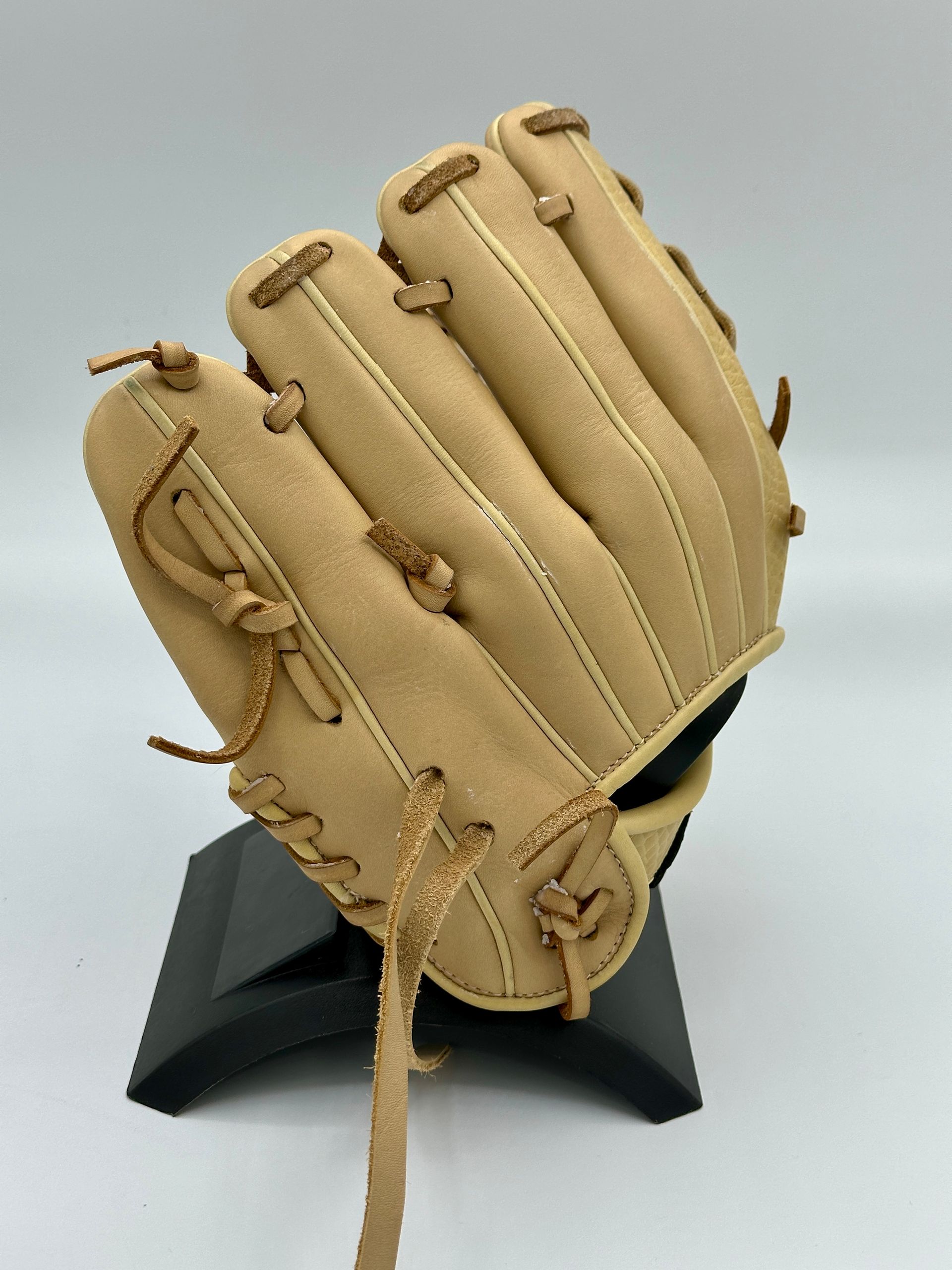 A baseball glove is sitting on a black stand