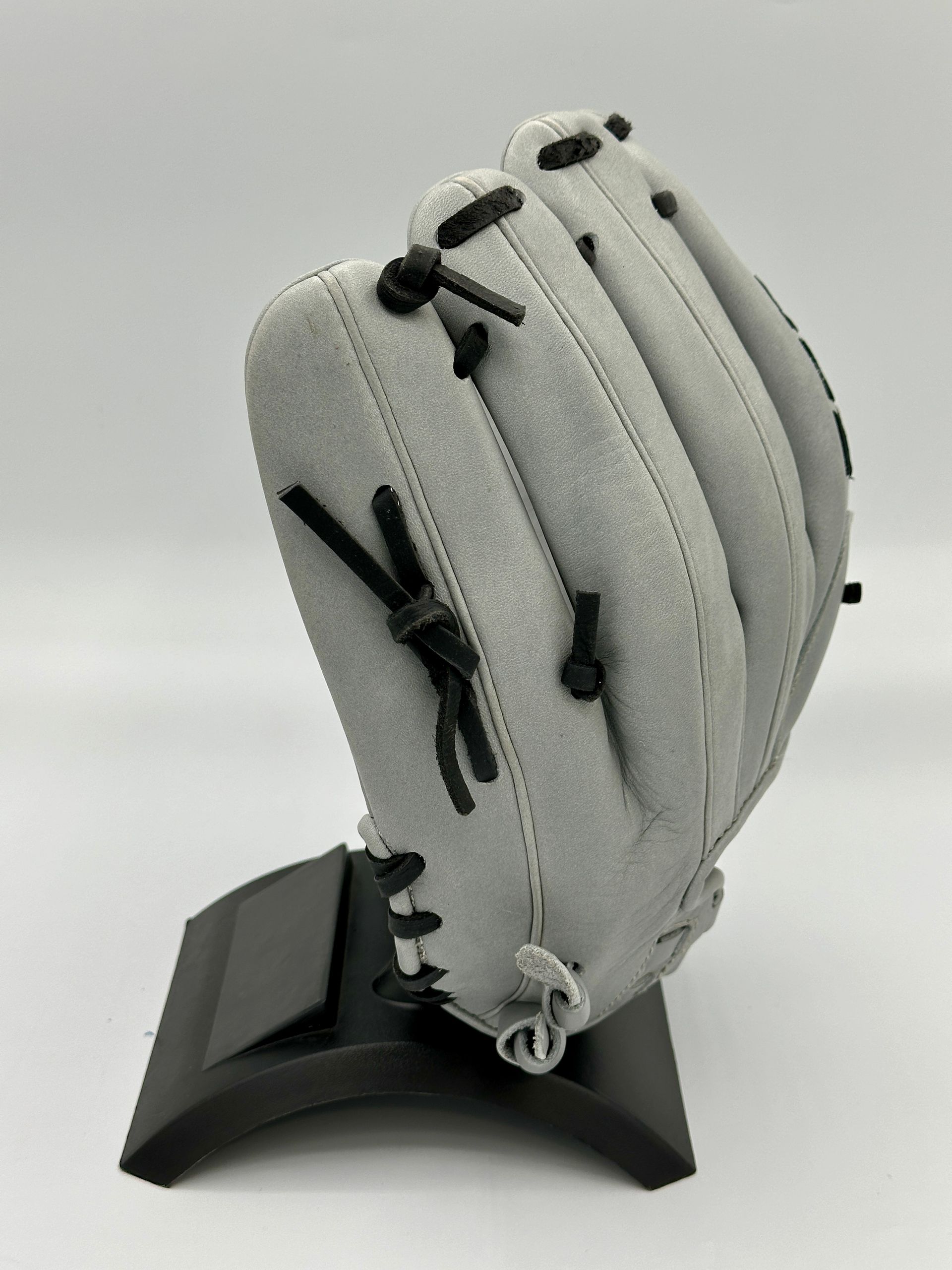 A baseball glove is sitting on top of a black stand.