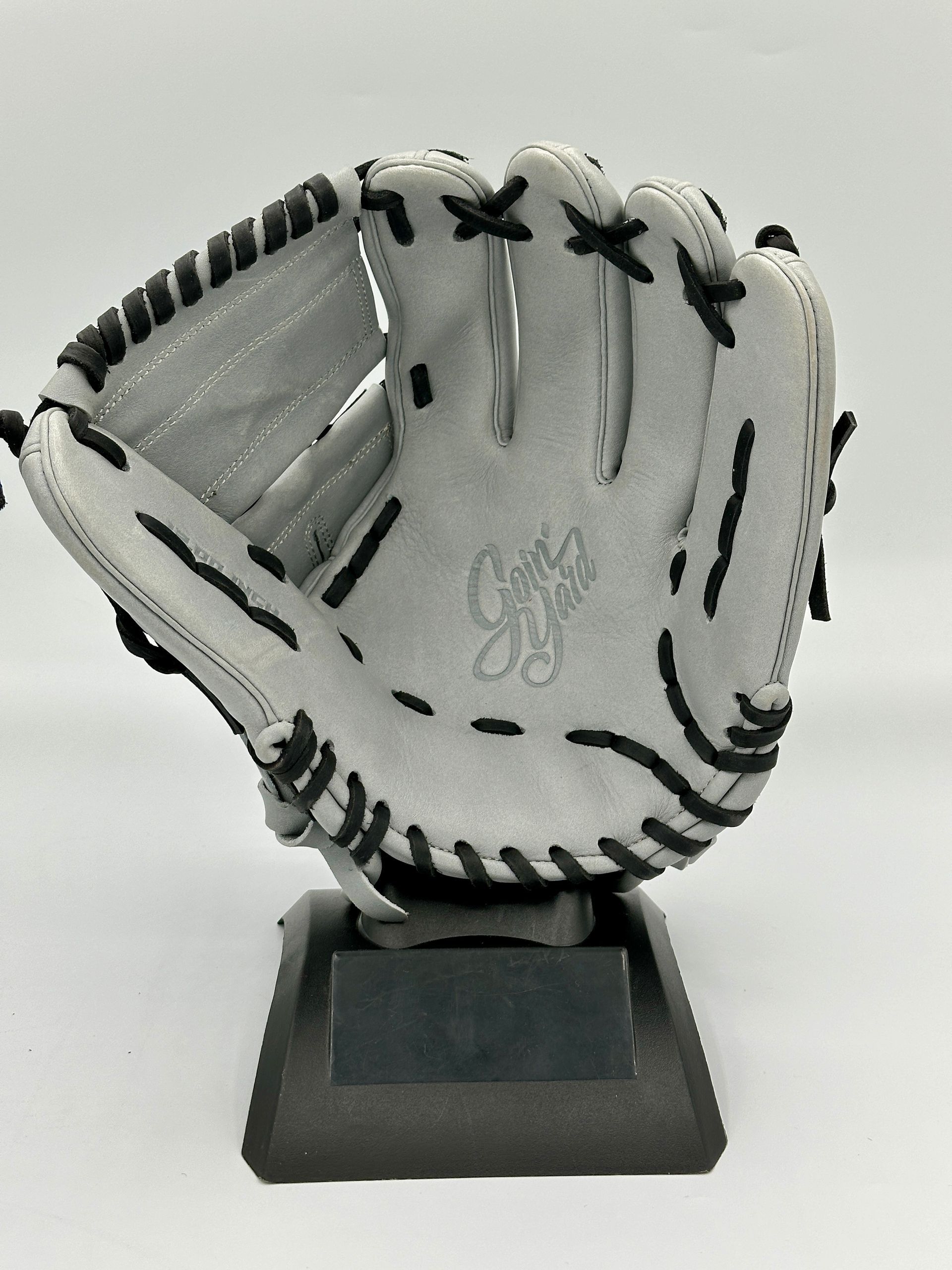 A white baseball glove is sitting on top of a black base.