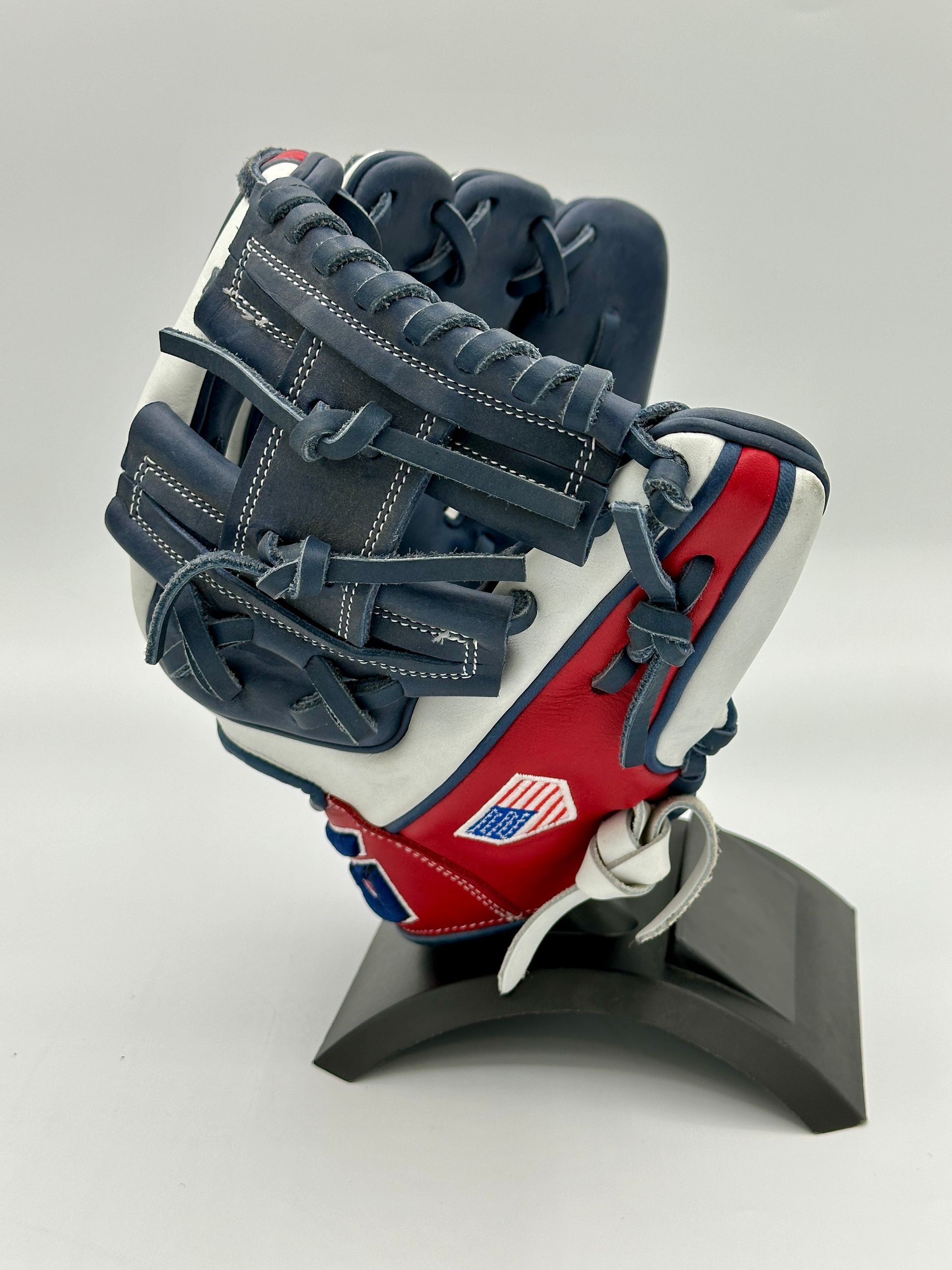 A red white and blue baseball glove on a stand
