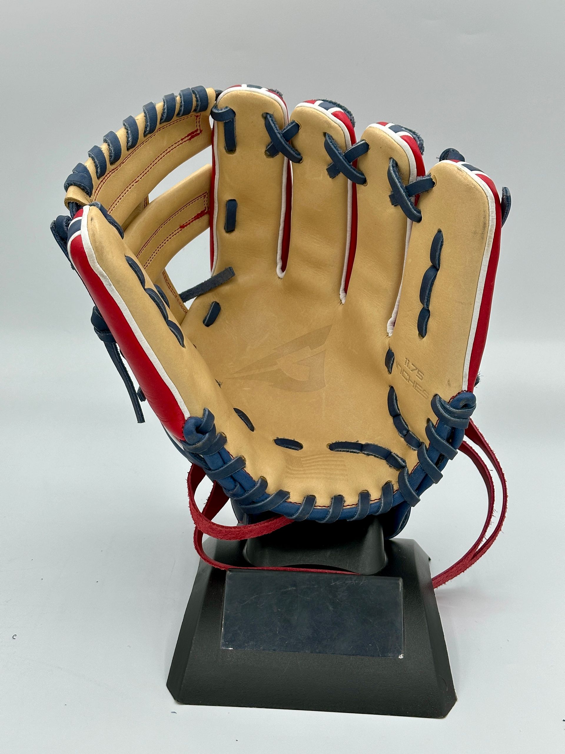 A red white and blue baseball glove on a stand