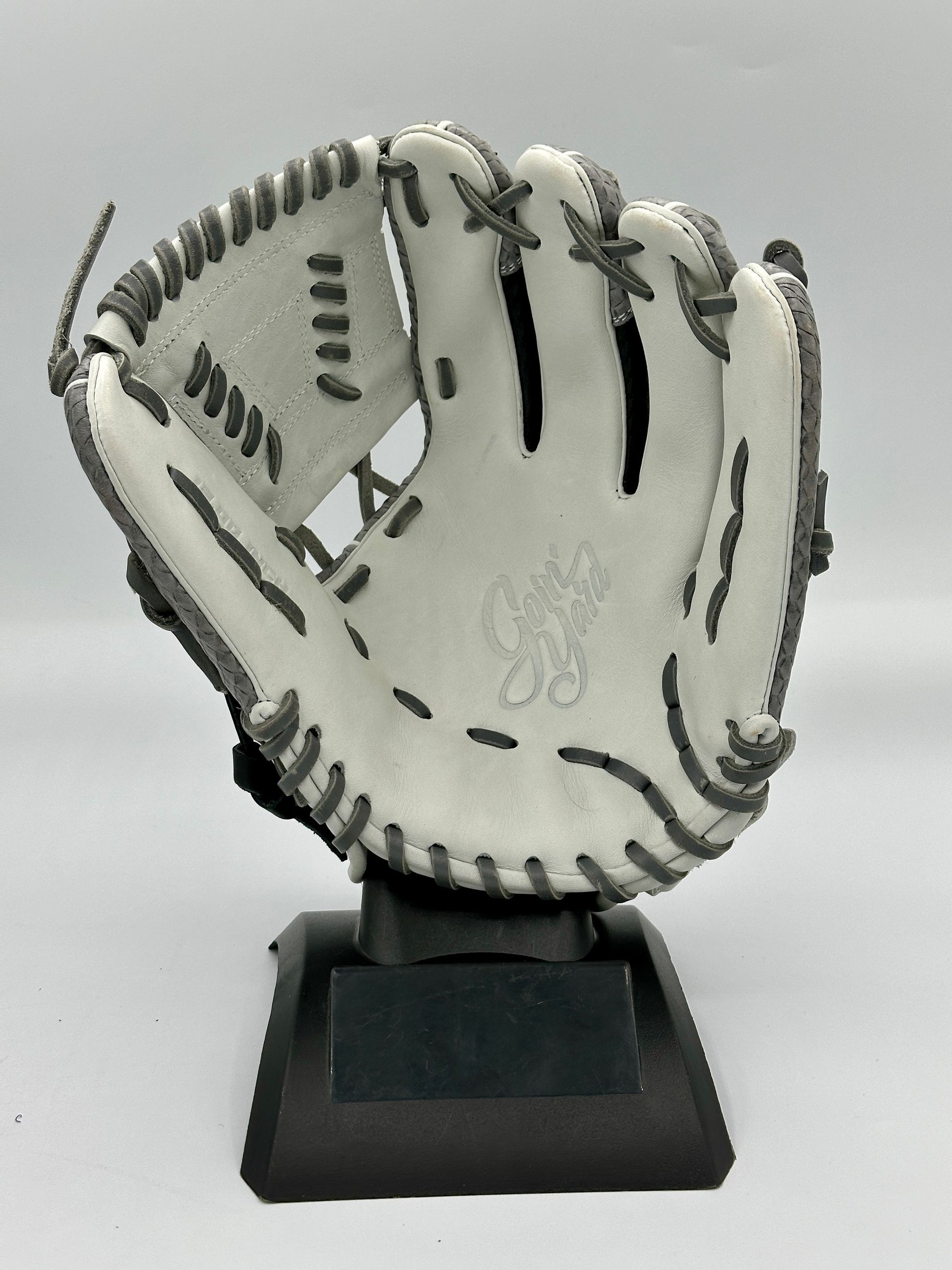 A white baseball glove is on a black base