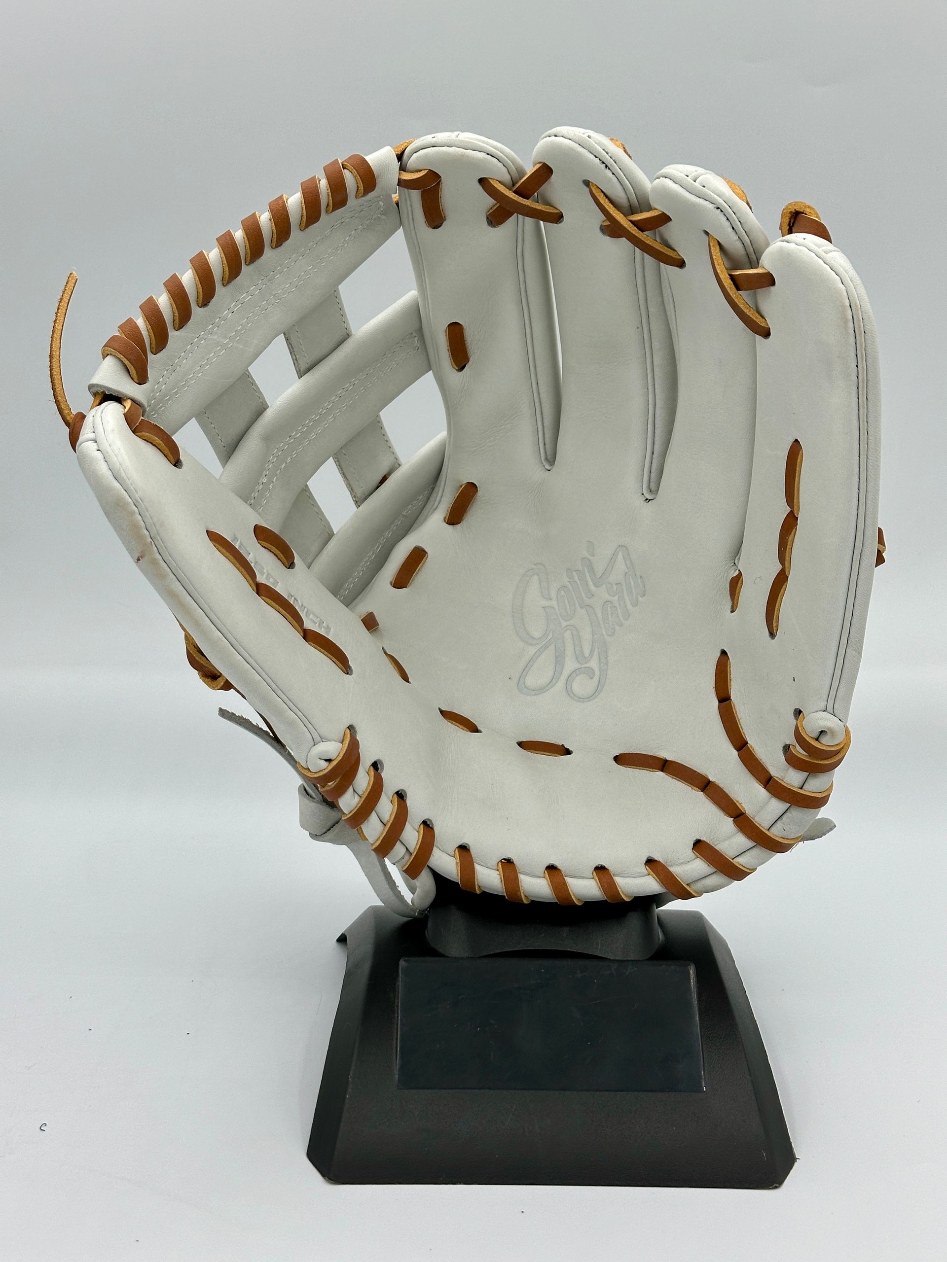 A white baseball glove is on a black base