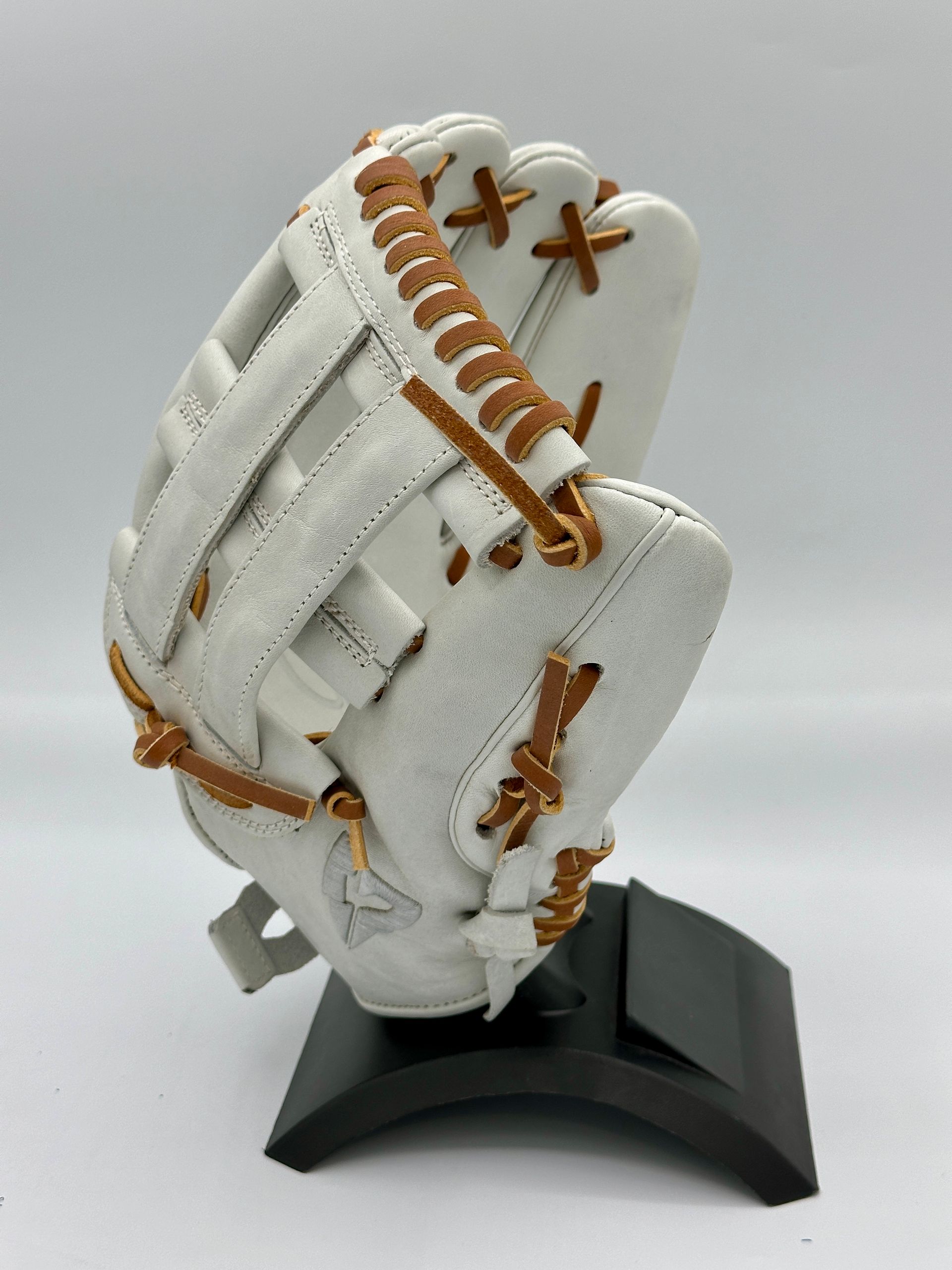 A white baseball glove is sitting on a black stand